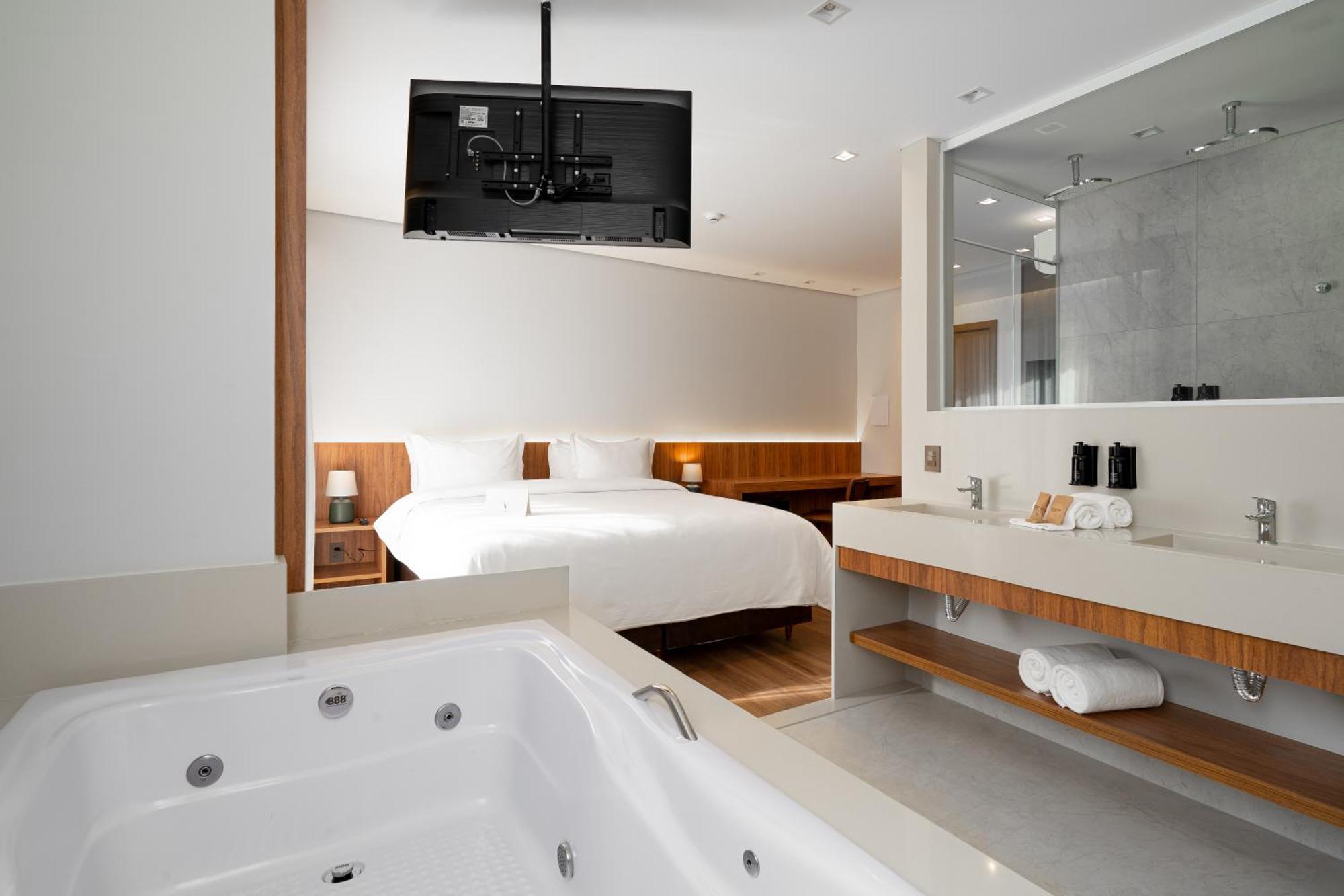 Suíte com cama king-size, varanda e banheira de hidromassagem